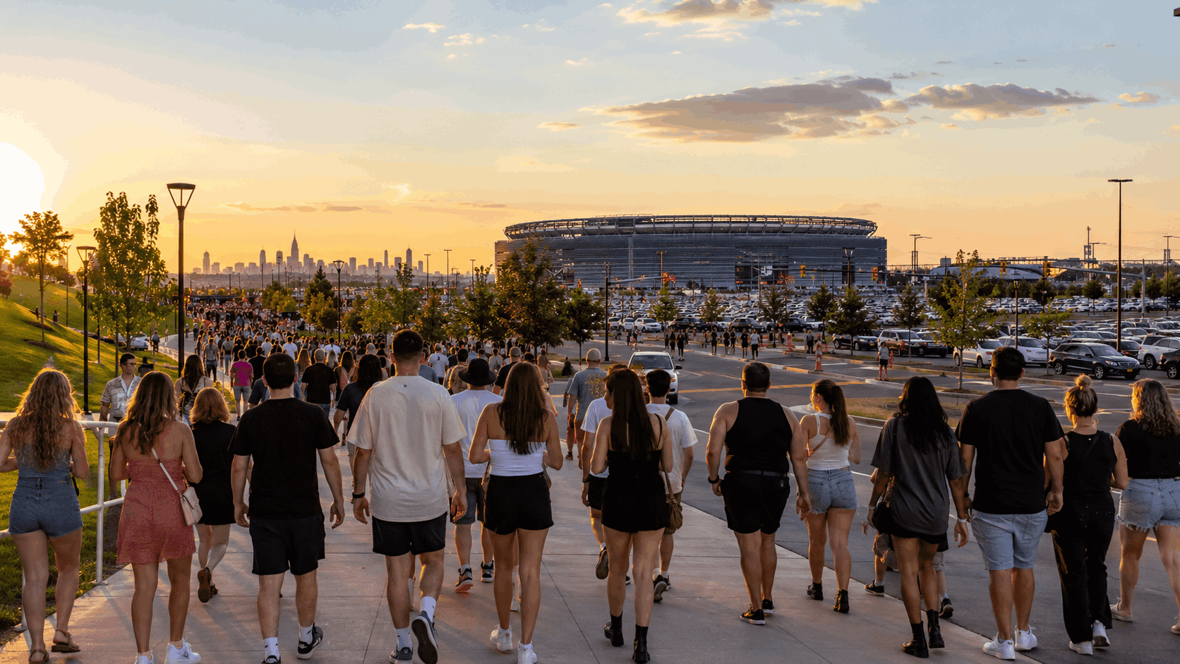 Crowds walking toward a North Jersey concert weekend near a major East Rutherford stadium at golden hour