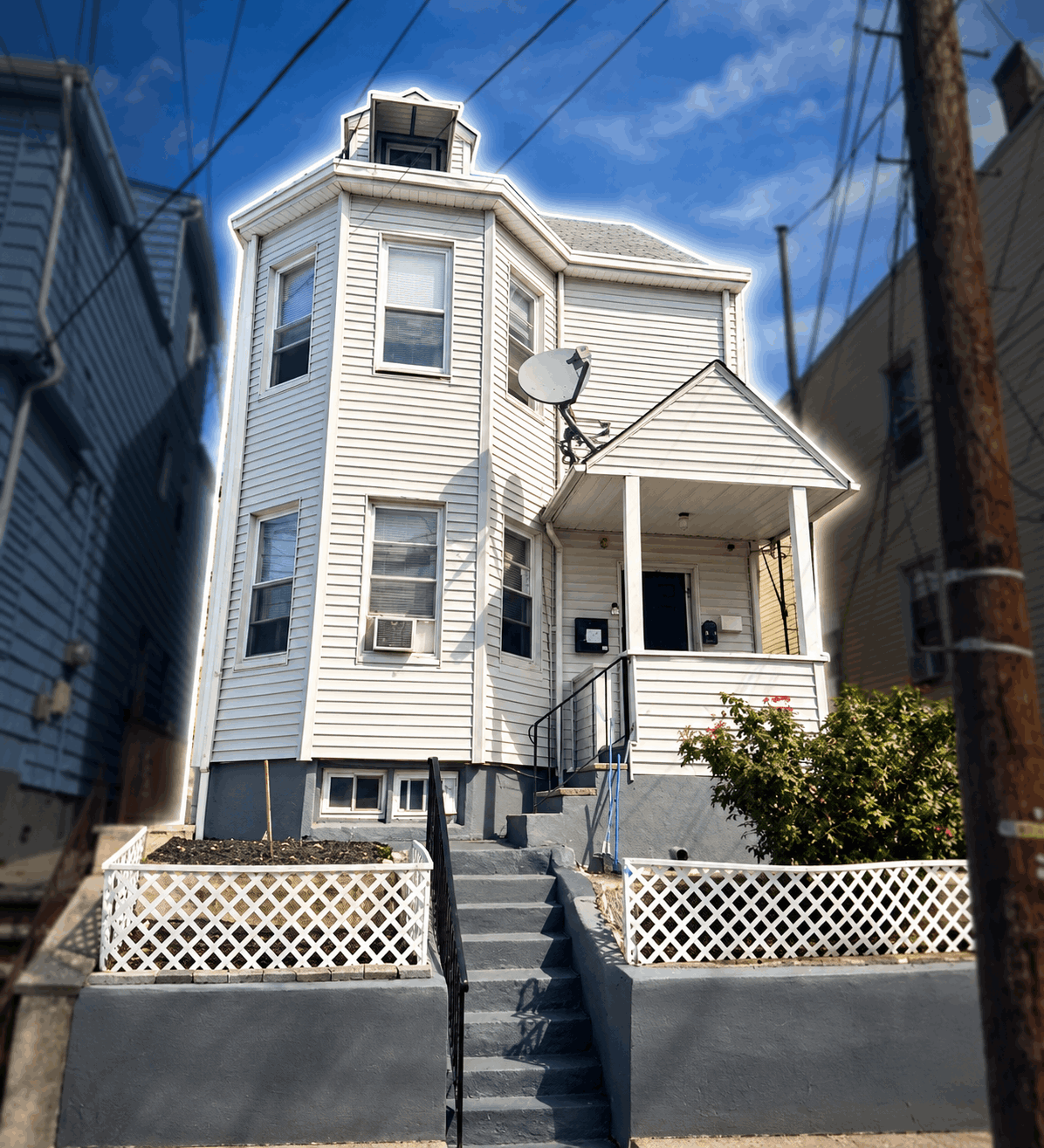 Highlighted exterior of a single-family home in Paterson, NJ, with driveway, landscaped front yard, and covered porch.