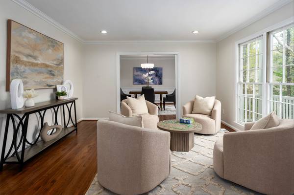 Filled with natural light from large front windows, this flexible living space flows seamlessly into the dining room, creating an inviting and connected feel.