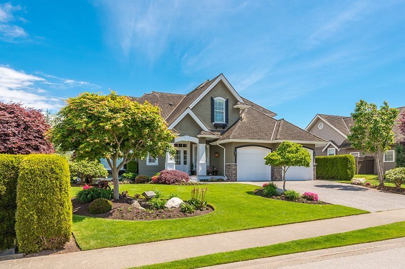 Front yard with fresh mulch, trimmed shrubs, and edged lawn
