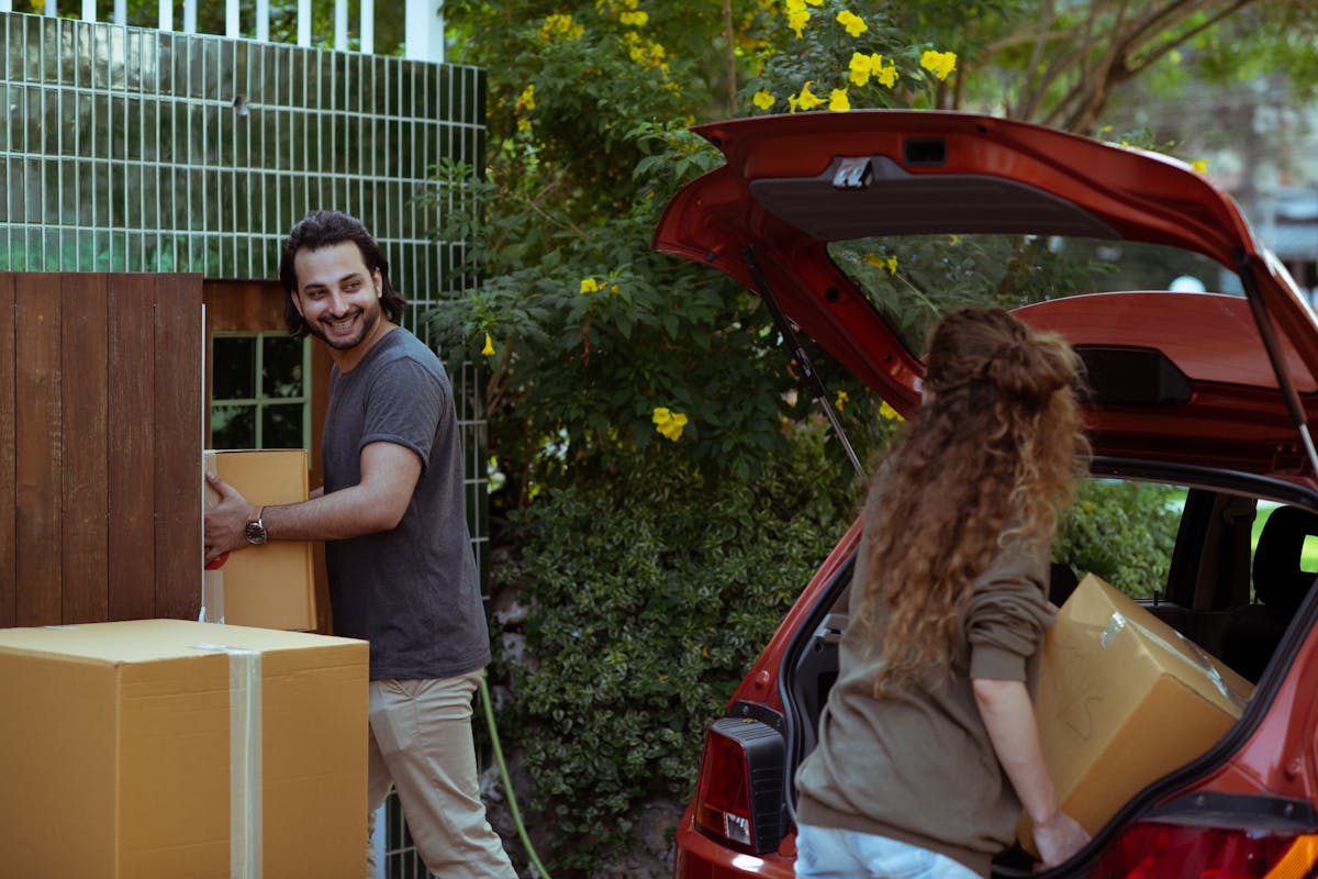 Couple carrying moving boxes into a home in Austin suburb