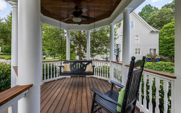 Covered porch with a swing and rocking chairs at a Charleston area home