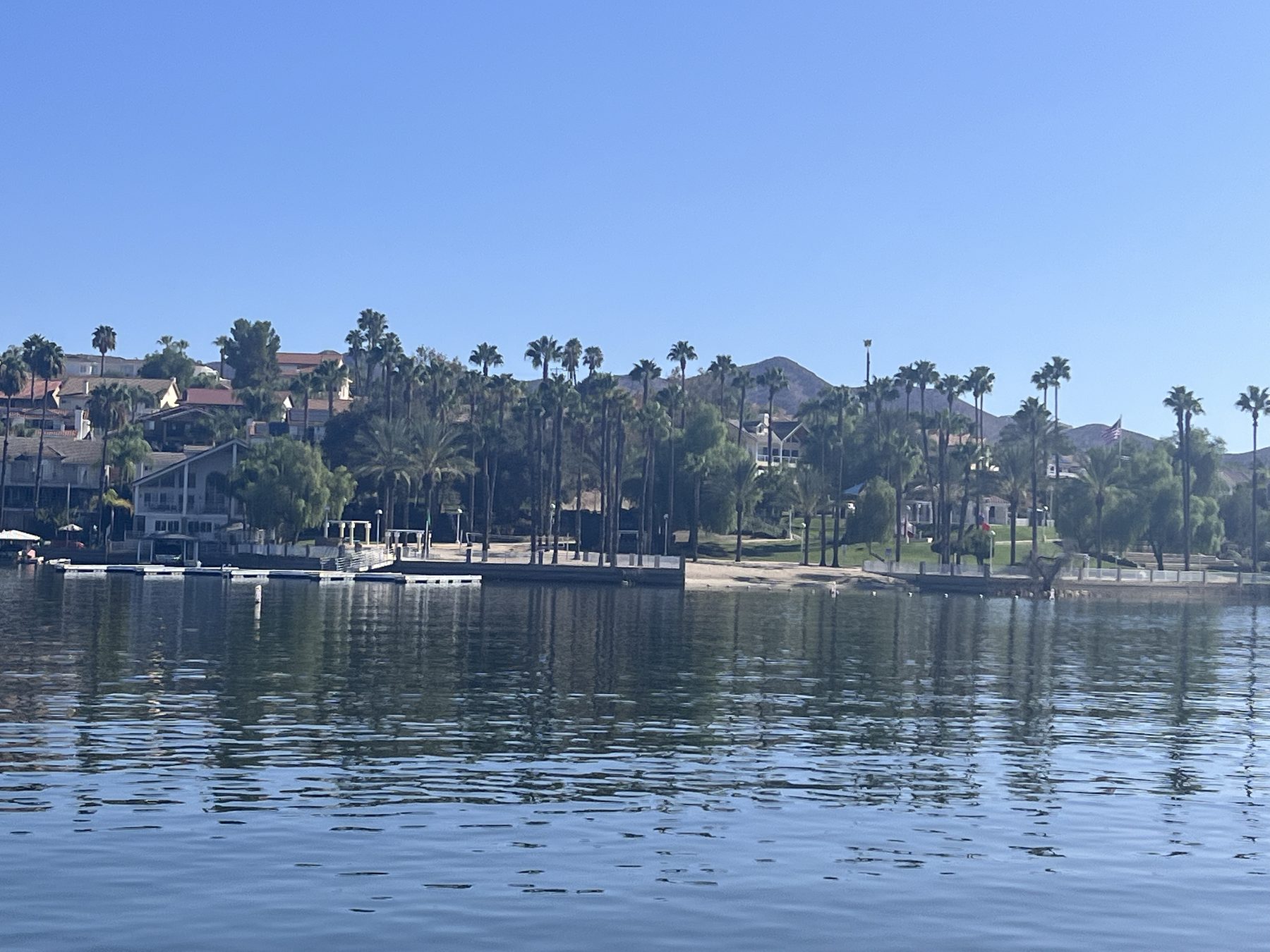 Waterfront homes with private docks along the shoreline of Canyon Lake, seen from the water.