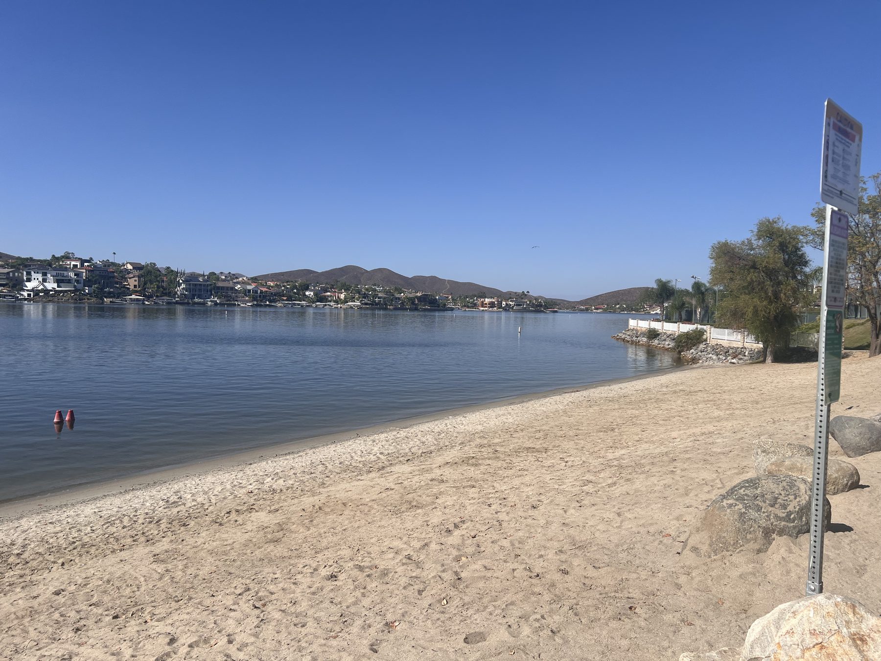 Sunset Beach at Canyon Lake, looking across the water to waterfront homes and the hills beyond.