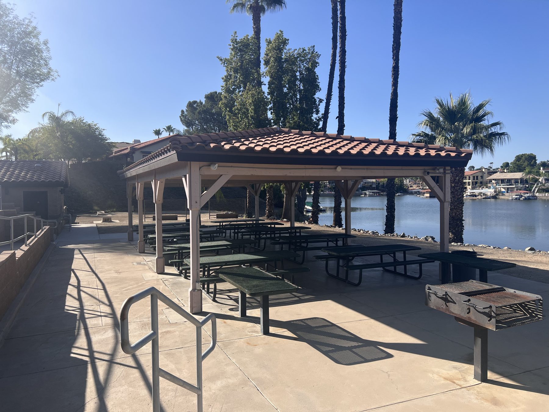 A covered picnic pavilion with barbecues overlooking the water at Roadrunner Park in Canyon Lake.