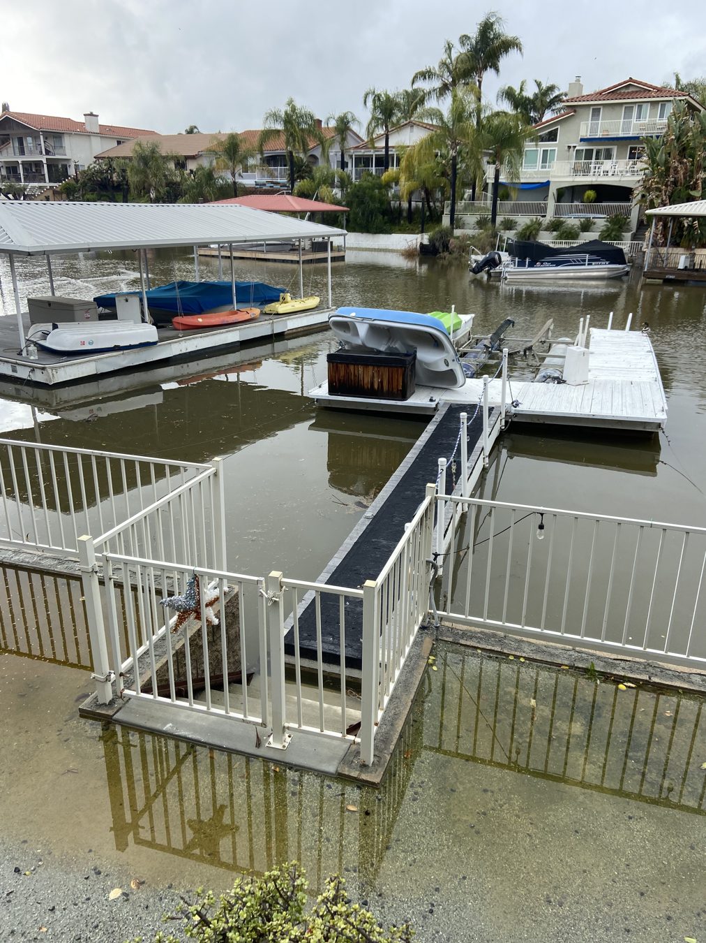 Floodwater covering a waterfront deck and dock gangway at Canyon Lake in February 2024.