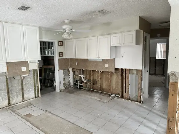 Interior of a hurricane-damaged home with lower drywall removed and wall framing exposed.