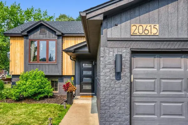 Black painted modern home with cedar accents and lush landscaping in Lakeville MN