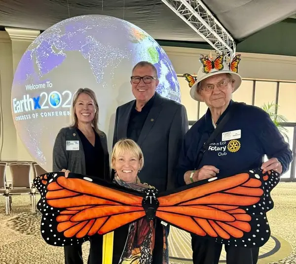 Alisa Morrison with Solana Beach Eco Rotary Club members at the EarthxCongress of Conferences 2026 in Dallas, Texas, posing with a giant monarch butterfly wing display