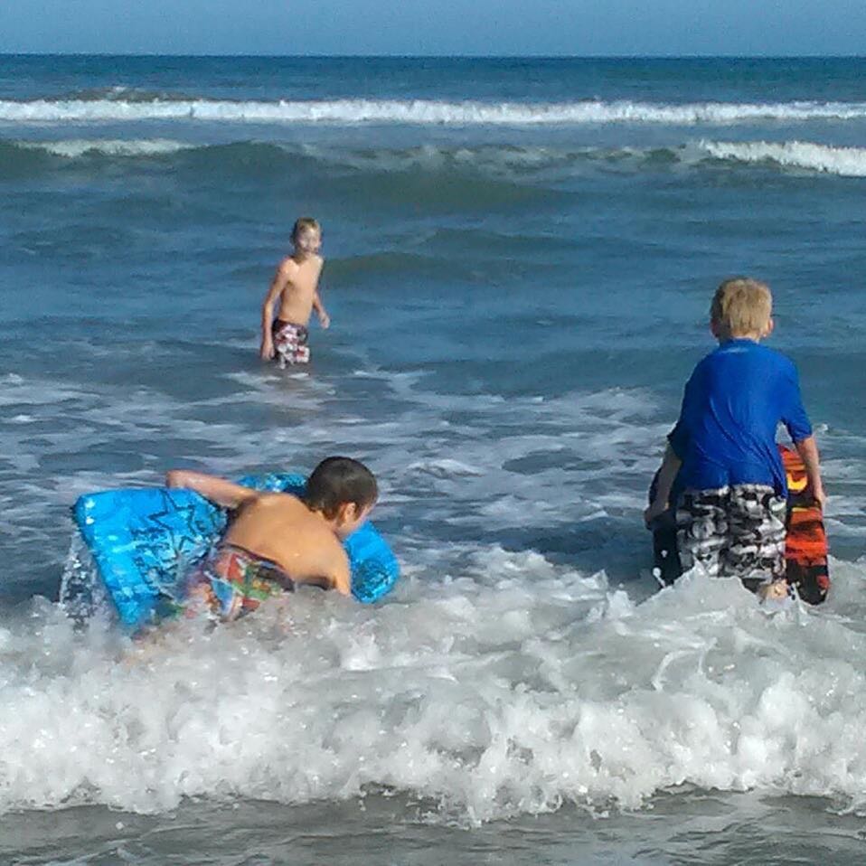 Children playing in the Atlantic Ocean at Satellite Beach, Florida — capturing everyday Space Coast lifestyle.