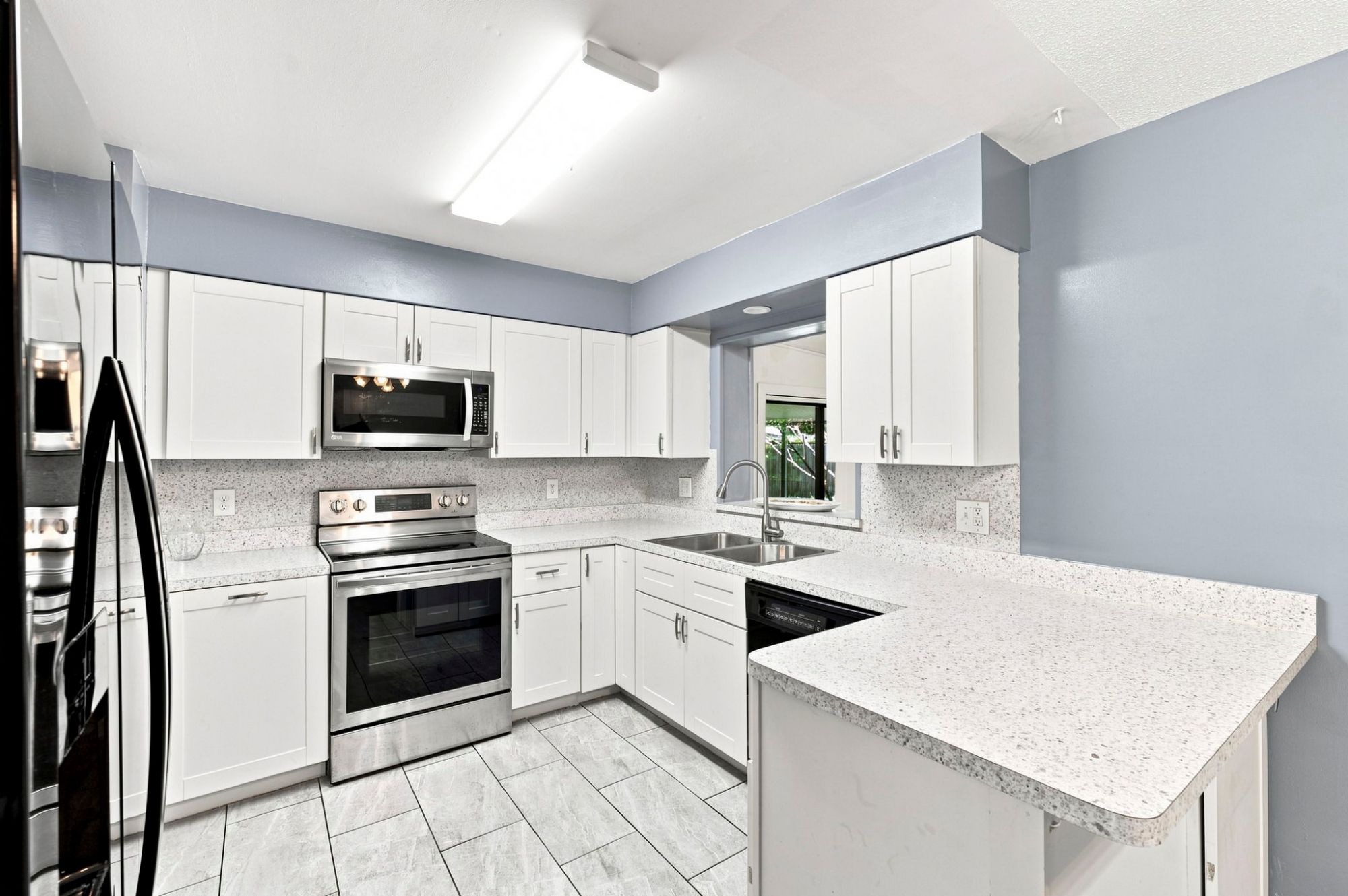 Updated kitchen with white cabinetry, stainless steel appliances and generous counter space at 1655 N Floral Ave in Bartow, FL.