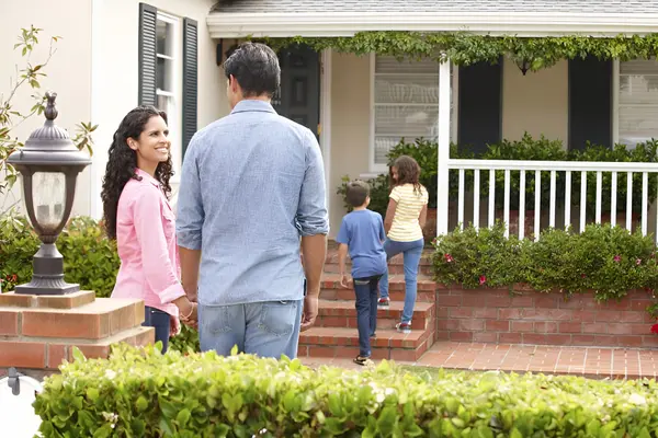 happy family in front of their new home
