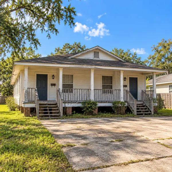 White duplex investment property with a front porch and two entry doors