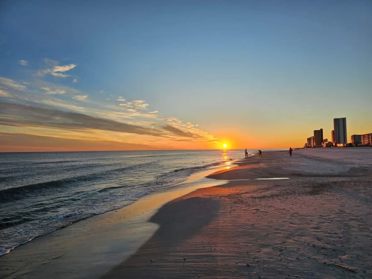 Sunset at Gulf Shores, Alabama, featuring white-sand beaches, Gulf Coast waterfront views, beachfront condos, and the relaxing coastal lifestyle that attracts homebuyers and investors.