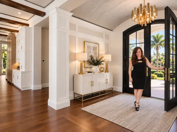 Stacy Russell Holding a Door Open In a Luxury Home