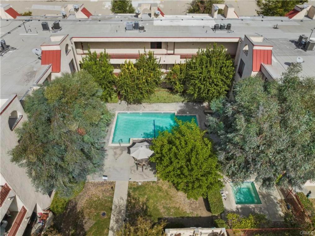 Aerial view of the Warner Gardens courtyard with the pool, spa and lawn between the three-story wings