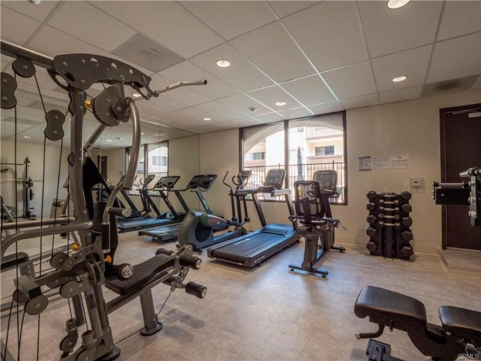 Encino Villas fitness room with treadmills, an elliptical, a cable machine and dumbbells