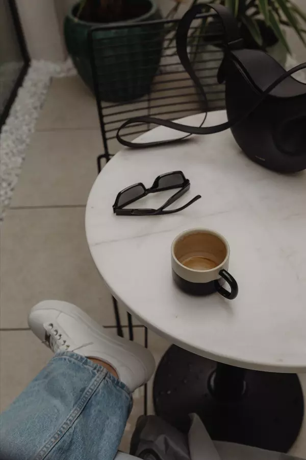 kaboompics_cozy-indoor-scene-woman-enjoying-a-cup-of-coffee-at-a-white-marble-table-32599