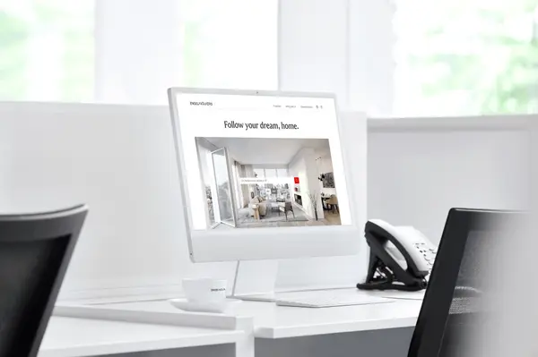 Modern White Desk with a computer display that says "Follow your Dream, Home." and picture of a beautiful property