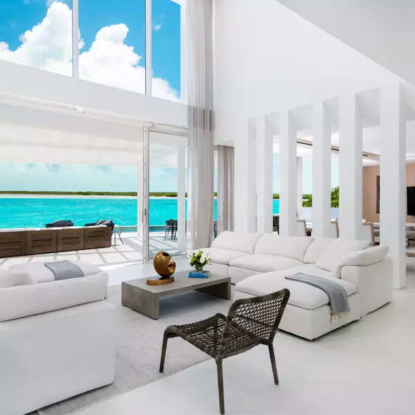 Luxury beachfront living room with panoramic ocean views and modern white interior design