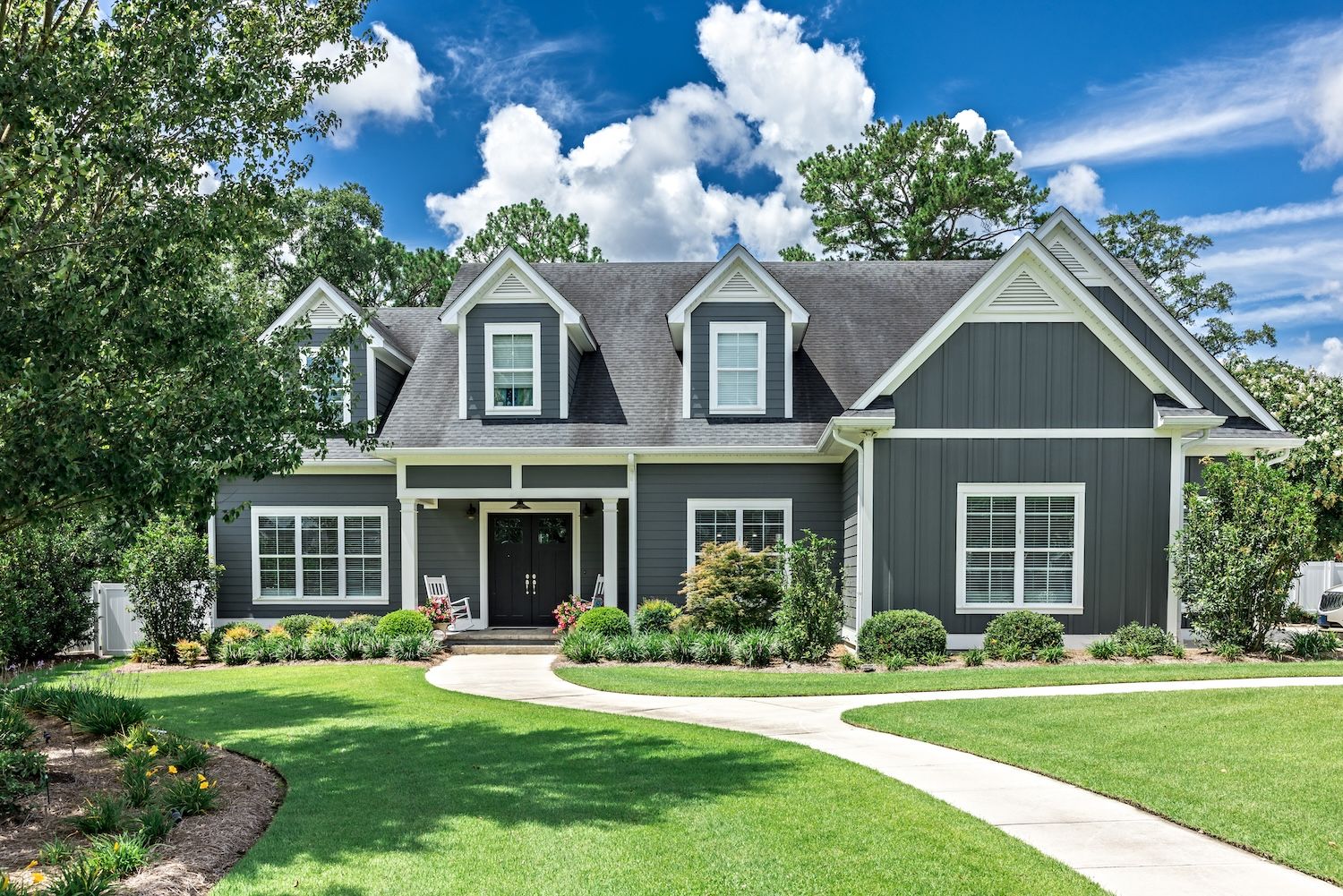 A large gray craftsman new construction house