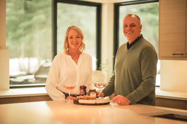 Beth in white top and eric in dark sweater in nice home with charcuterie