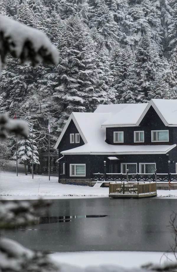 blue lakehouse in winter with snow on roof