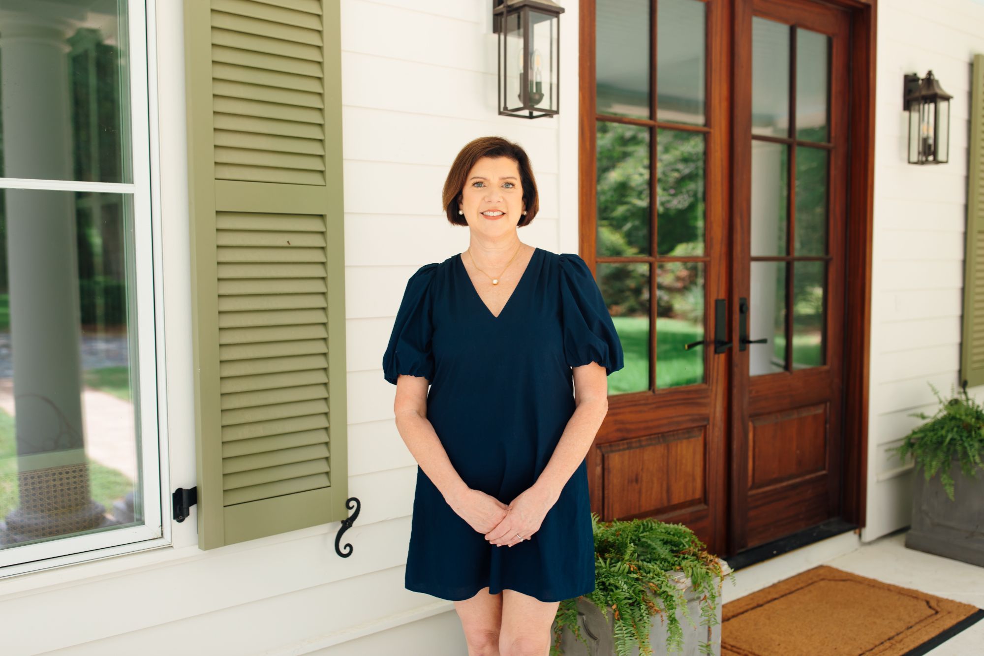 Stacie Boone by a front door