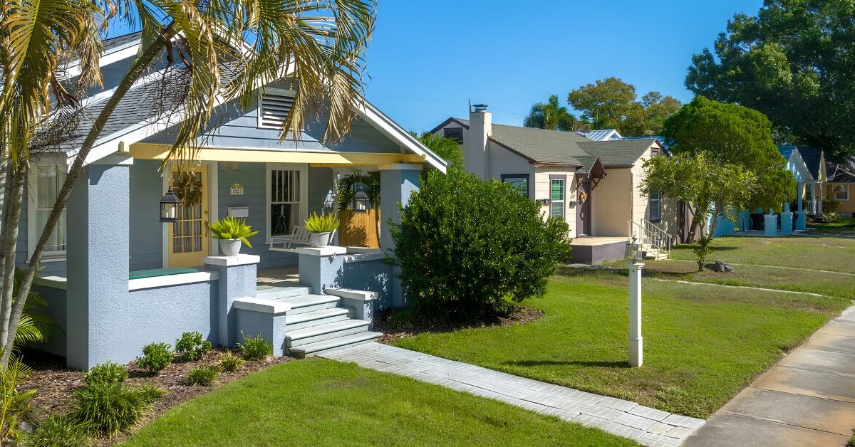 Blue-gray craftsman bungalow with a landscaped walkway on a quiet street in Greater Woodlawn, St. Petersburg, FL