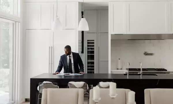 Engel & Volkers advisor looking over materials on counter of the kitchen