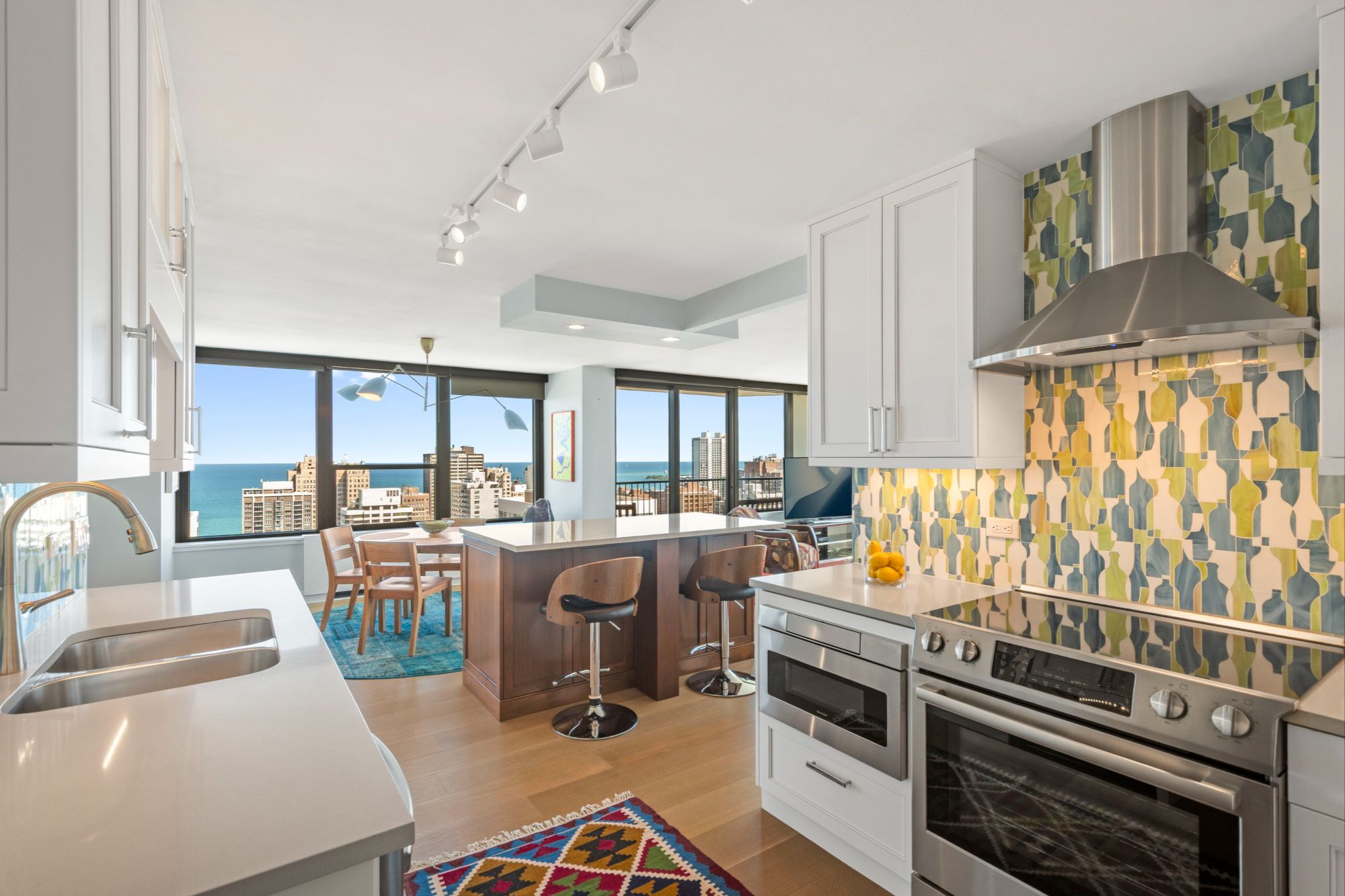 Shot of the kitchen showing the stone island set against the window backdrop. 1560 N Sandburg Terrace