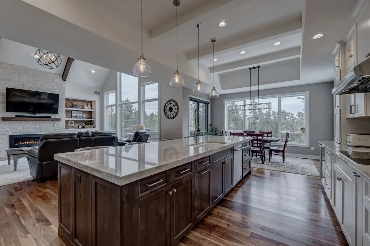 luxury white kitchen with large island and marble counter tops and great room in a grounded luxury style