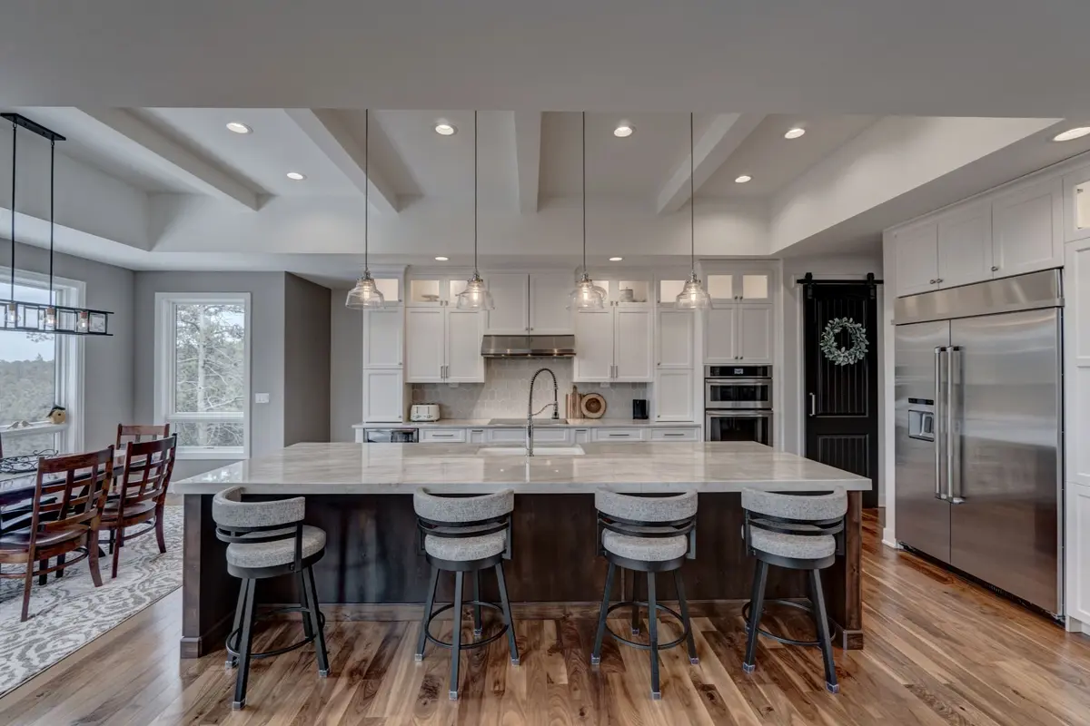 luxury white kitchen with large island and marble in a grounded luxury style
