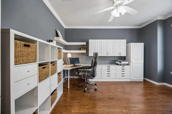 Dedicated home office with built-in desk, shelves, and cabinetry