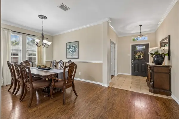 Entry and formal dining room with crown molding and updated flooring