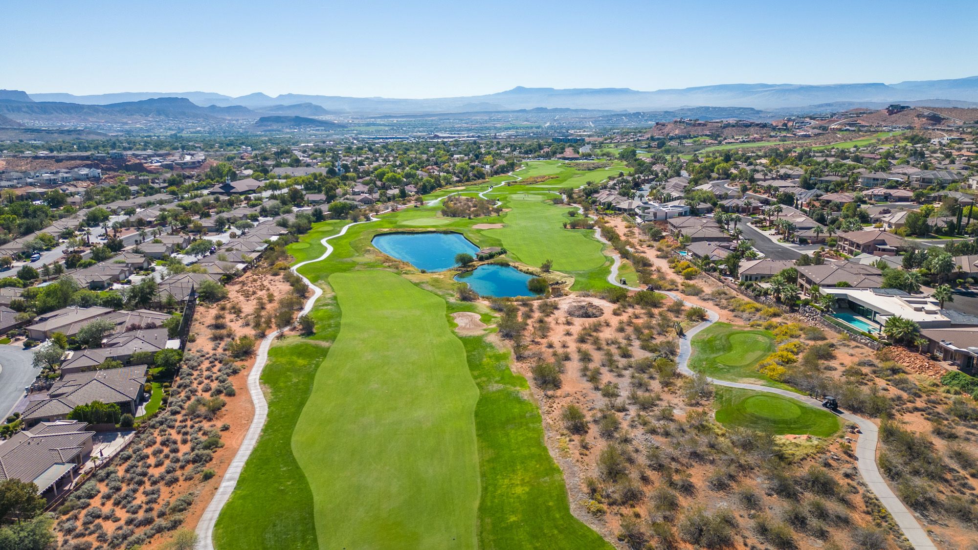St George Utah golf course with fairway, ponds, and surrounding golf-view homes in a desert neighborhood