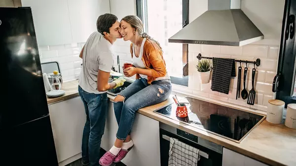 young straight couple washing up kiss on cheek