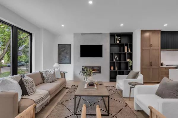 Stylish modern living room in a Saskatoon home with large windows, fireplace, and built-in shelving — showcasing 'move-in' ready interiors that attract today’s buyers