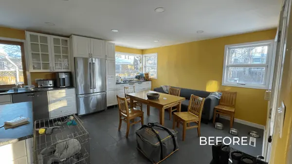 Kitchen before updates in a Saskatoon home, with yellow walls, cluttered counters, mismatched furniture, and dated presentation.