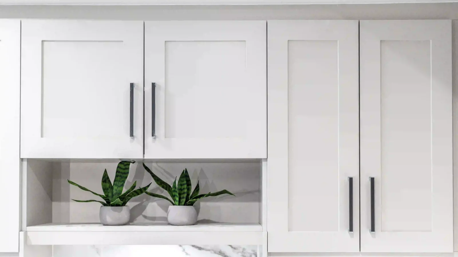 White shaker kitchen cabinets with an open shelf in a Liberty Encore display home