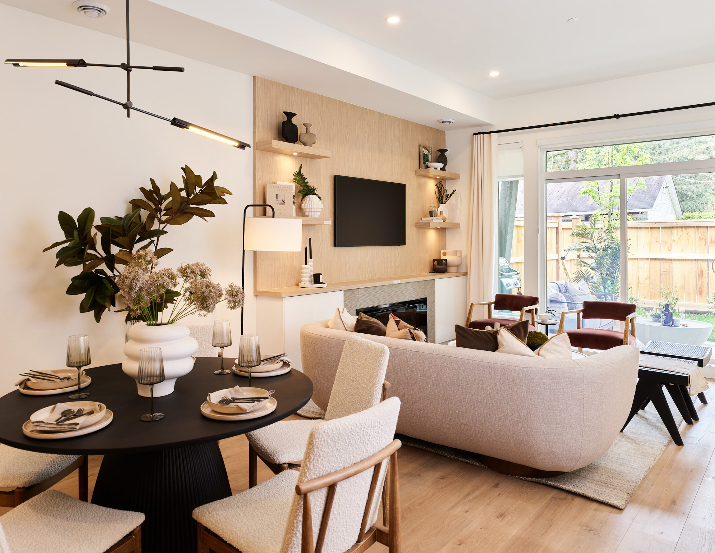 Everwood townhome living and dining area with modern fireplace, pendant lighting, and patio doors opening to yard