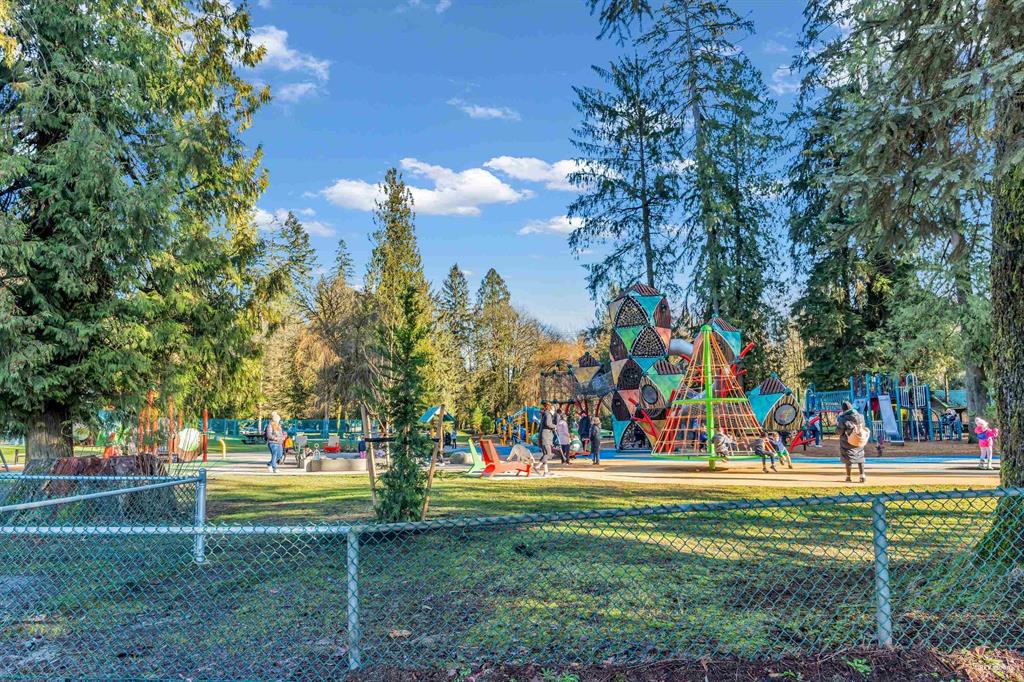 Silver Valley playground with kids playing, surrounded by mature evergreens