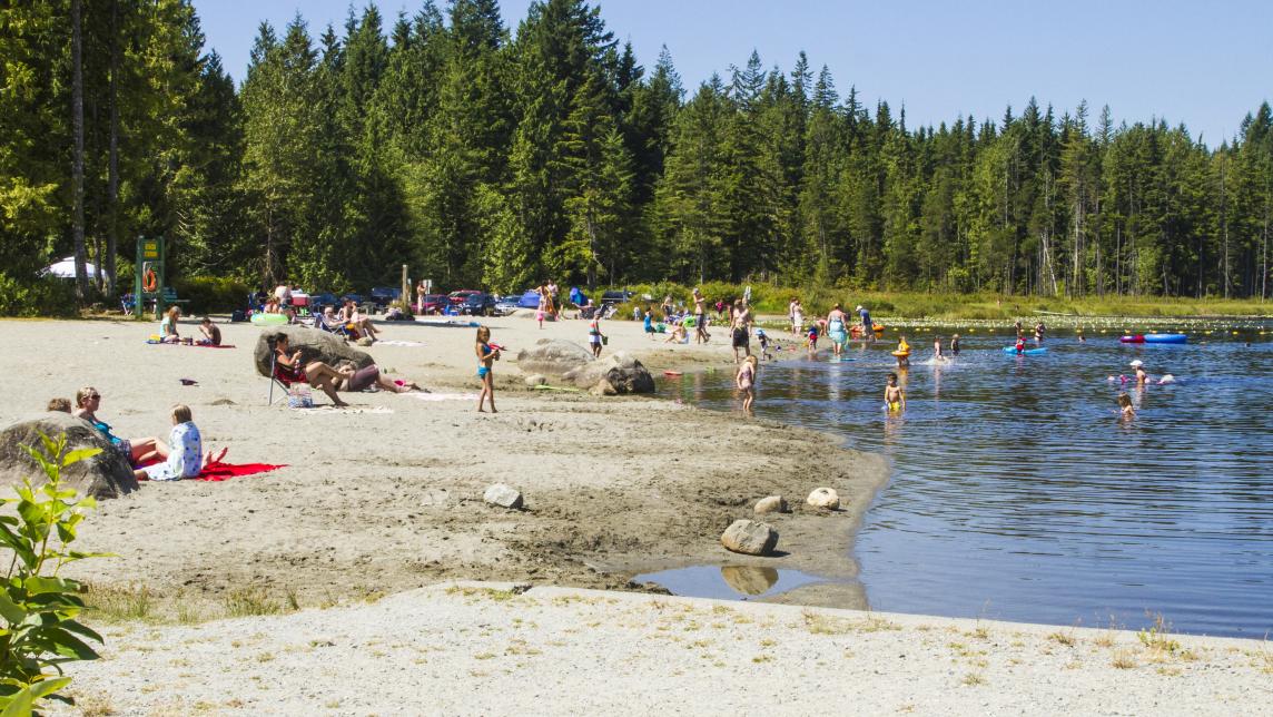Whonnock Lake summer beach scene with families swimming and on the sand