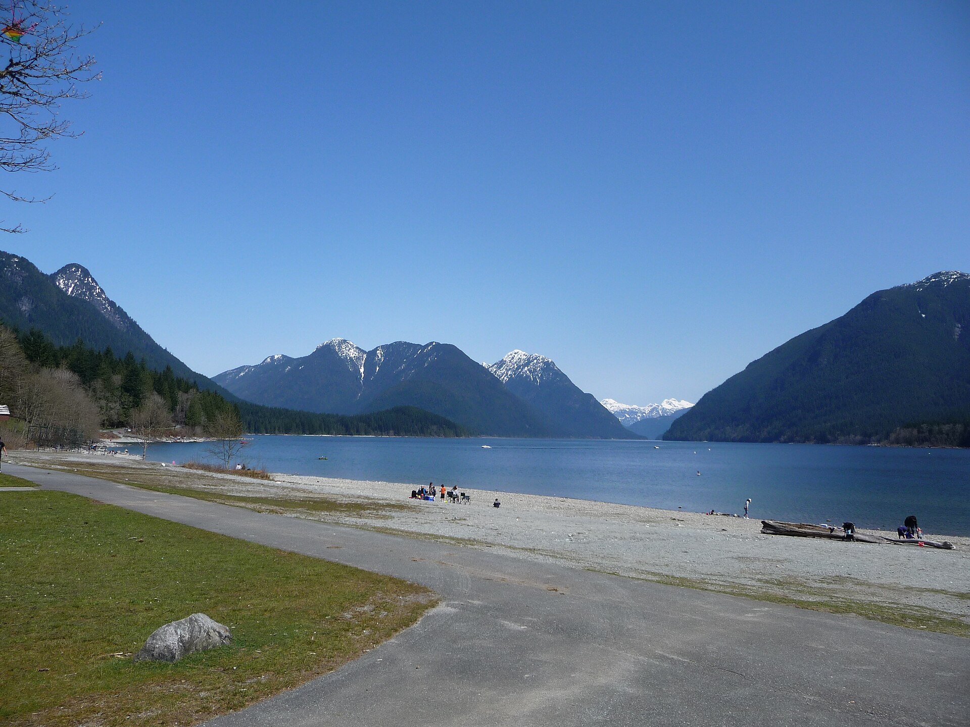 Alouette Lake beach with snow-capped mountains and blue sky