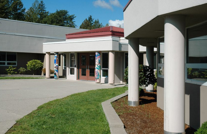 Albion Elementary School entrance with Indigenous art columns and blue sky