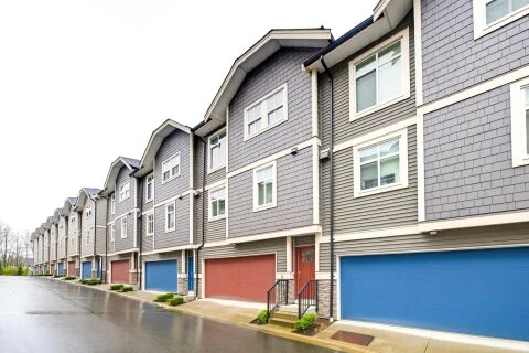 Eden Square townhomes Bridgeview, with red & blue garage doors
