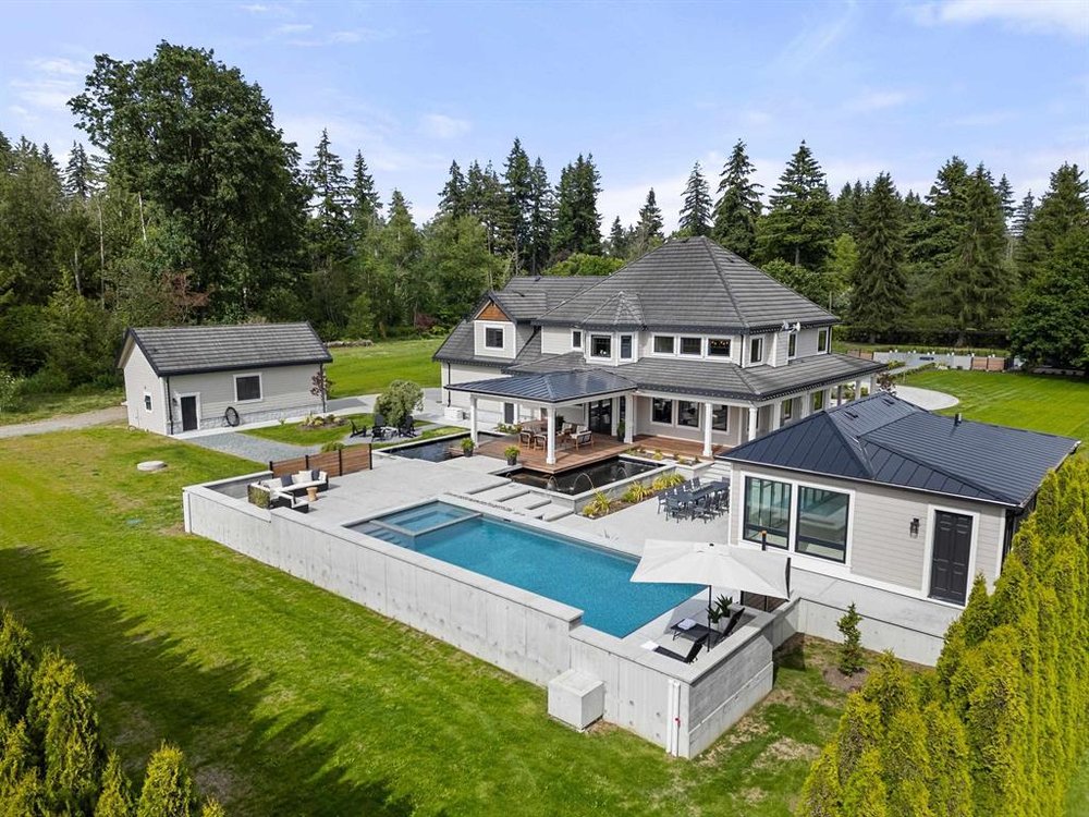 White modern farmhouse with covered porch on a Glen Valley acreage