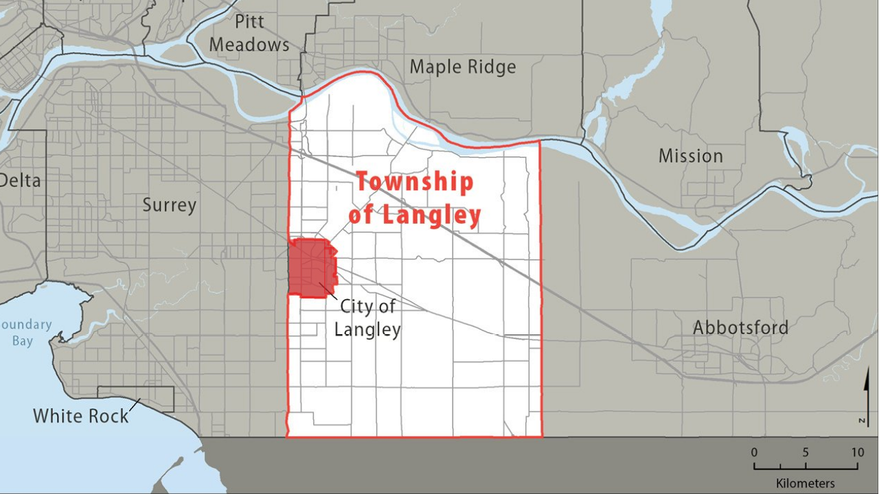 Map of the Township of Langley outlined in red, with the City of Langley as a small red square inside, between Surrey to the west & Abbotsford to the east