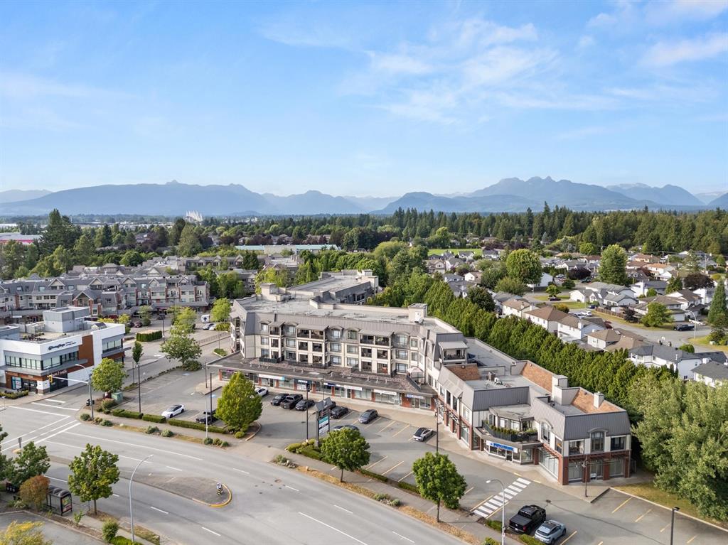 Aerial view of condos over shops in Walnut Grove, with the mountains behind
