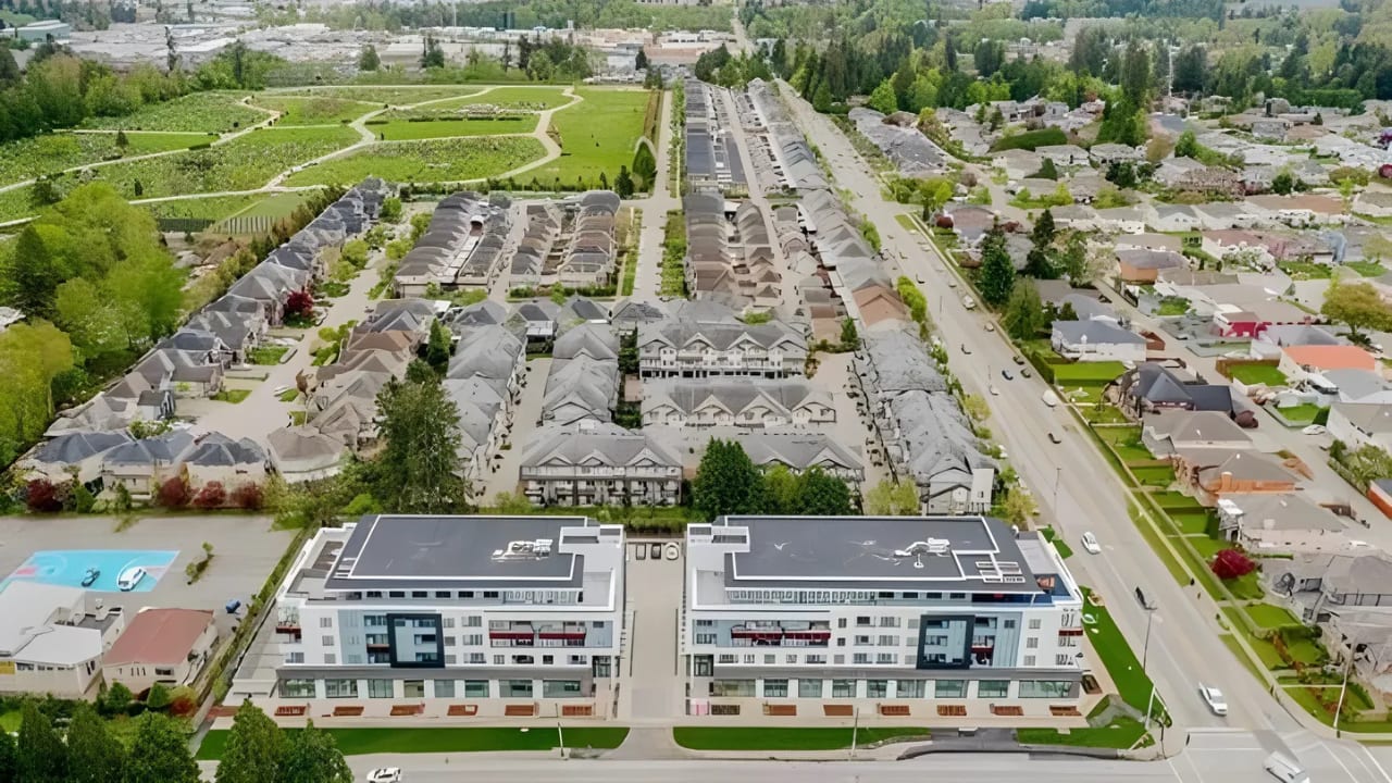 Aerial view of a main road through East Newton, lined with townhomes and a new mid-rise